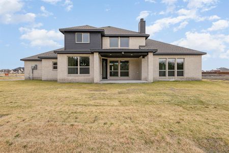 Rear view of house featuring a yard and a patio