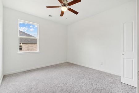 Spare room featuring ceiling fan and light carpet