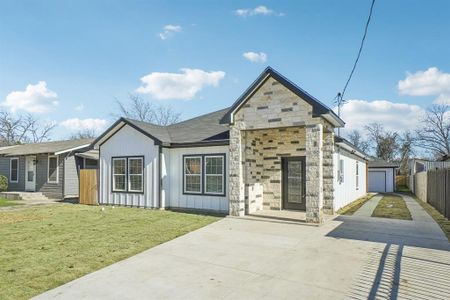 View of front of property featuring a garage and a front lawn