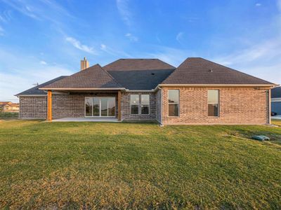 Rear view of property with a yard and a patio