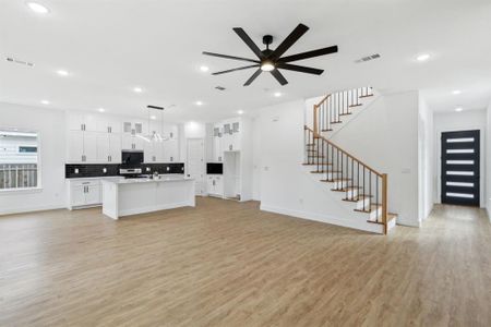 Unfurnished living room with light hardwood / wood-style floors and ceiling fan