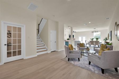 The first floor office can be seen through the glass door to the left. Light colored laminate wood flooring throughout makes the space bright and modern.