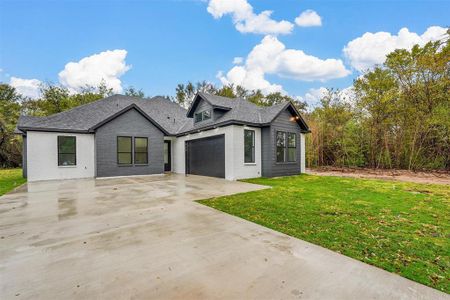 View of front of house with a garage and a front lawn