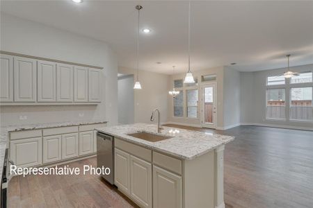 Kitchen with stainless steel dishwasher, plenty of natural light, sink, and decorative light fixtures