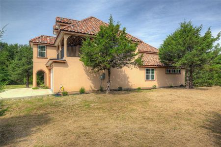 View of side of home featuring a yard and a patio area