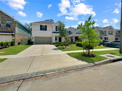 Great Neighborhood with modern two-story houses, manicured lawns, sidewalk, and mature trees .