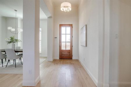 Entrance with a chandelier and light hardwood / wood-style floors