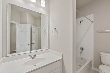 The secondary bath features tile flooring, white cabinetry and light countertops and a shower/tub combo. Perfect for accommodating any visiting family and friends.