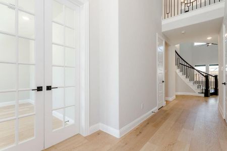 Corridor with light hardwood / wood-style floors and french doors