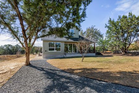 Back of house with a lawn and roof with shingles