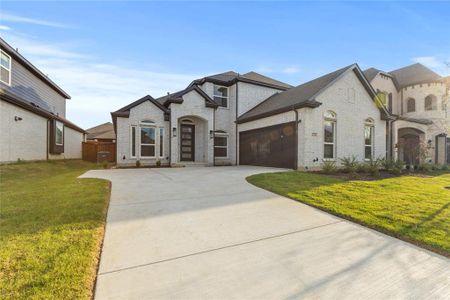 French country home featuring a garage and a front yard