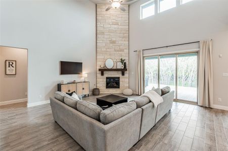 Living room with plenty of natural light, ceiling fan, a fireplace, and hardwood / wood-style flooring