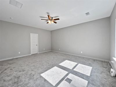 Carpeted spare room featuring ceiling fan