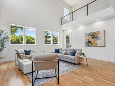 Living room with a high ceiling and light wood-type flooring