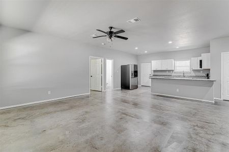 Unfurnished living room featuring sink and ceiling fan