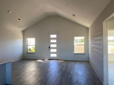 Entrance foyer featuring hardwood / wood-style floors and vaulted ceiling