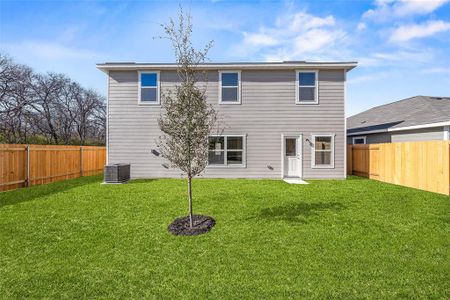 Back of property featuring a fenced backyard, a yard, and central air condition unit