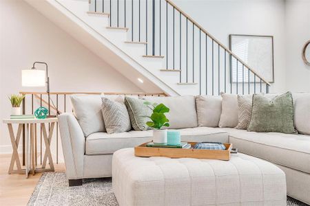 The elegant staircase, adorned with white oak hardwoods and designer railings, serves as a stunning focal point of the home.