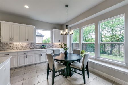 Tiled dining space with plenty of natural light and an inviting chandelier