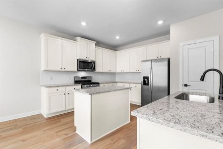 Beautiful and modern kitchen featuring sleek granite countertops, stainless steel appliances, and a spacious island. The open layout and natural light create a welcoming and functional space, perfect for cooking and entertaining