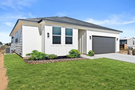 You're looking at a modern single-story home with a clean white exterior, featuring large windows and a two-car garage. The property boasts a well-maintained lawn and a simple yet elegant landscaping with a rock garden.