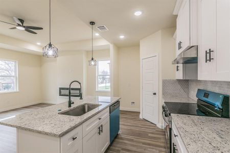 Kitchen with sink, white cabinetry, a kitchen island with sink, and stainless steel appliances