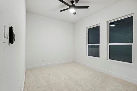 Empty room featuring ceiling fan and light colored carpet