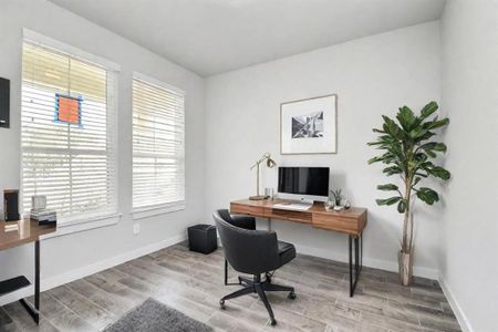 Experience the perfect blend of sophistication and warmth in this home office, boasting elegant wood-look tile flooring and flooded with natural light from expansive windows and French doors. Sample photo of completed home with similar floor plan. Actual colors and selections may vary.