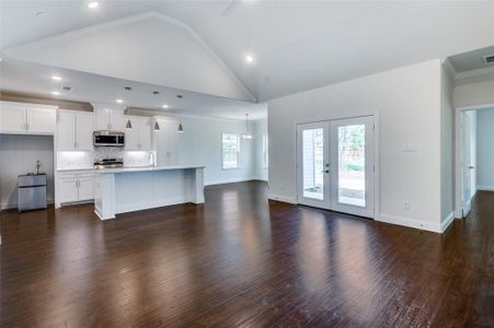 Unfurnished living room with sink, crown molding, french doors, and dark hardwood / wood-style flooring