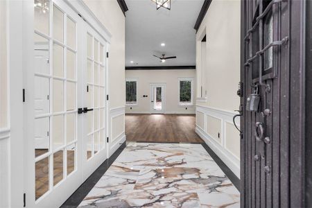 From the minute you walk through the front door, you will immediately start noticing the custom touches and quality. notice the crown molding, marble tile, Wall details, open niche on the right and the trim around the doors and we've only arrived in the entry.