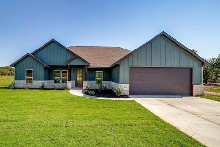 View of front of property featuring a front lawn and a garage