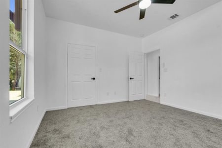 Unfurnished bedroom featuring carpet flooring and ceiling fan