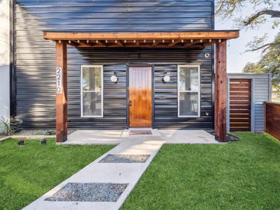 Property entrance featuring a lawn and a patio