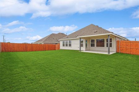 Back of property with a lawn and a patio