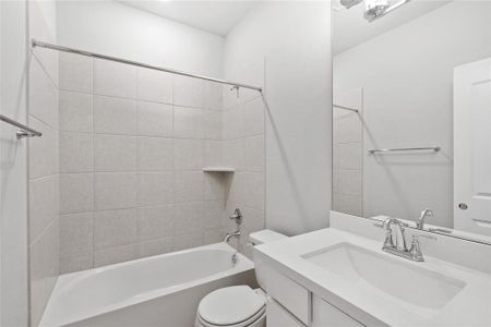 The downstairs secondary bathroom is conveniently located near the secondary bedrooms, offering easy access for guests or family members. It features modern fixtures and a sleek design, combining style and functionality.