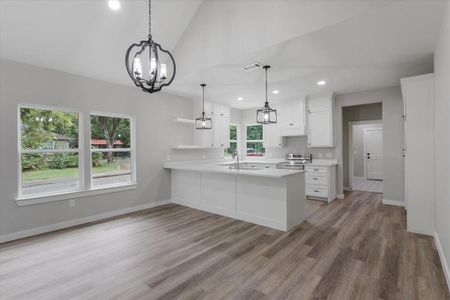 Kitchen with a healthy amount of sunlight, stainless steel electric range oven, and white cabinetry