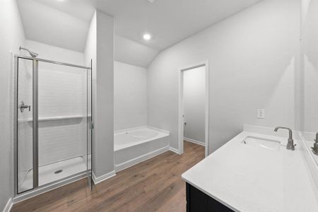 Bathroom with vanity, shower with separate bathtub, hardwood / wood-style flooring, and vaulted ceiling