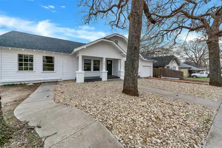 Ranch-style house featuring an attached garage, fence, and roof with shingles