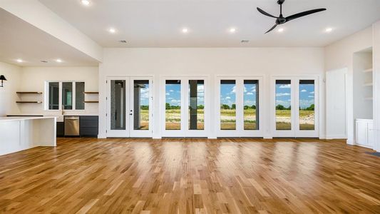 Unfurnished living room featuring ceiling fan and light hardwood / wood-style flooring