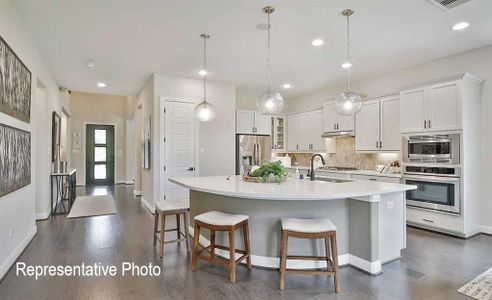 Kitchen with tasteful backsplash, an island with sink, sink, white cabinetry, and appliances with stainless steel finishes