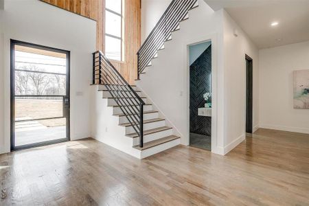 Foyer with recessed lighting, light wood-style flooring, baseboards, and stairs