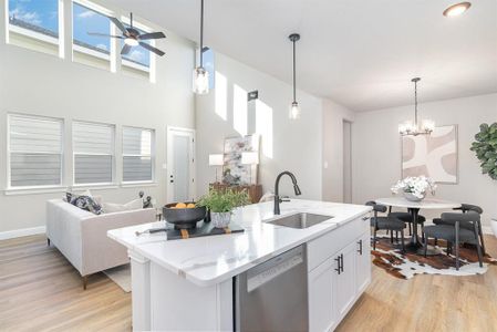 Kitchen featuring dishwasher, a kitchen island with sink, sink, light hardwood / wood-style floors, and white cabinetry