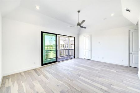 Primary suite with vaulted ceilings and a balcony