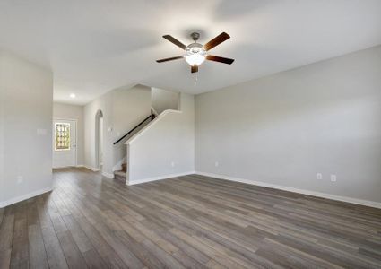 Spacious living room with a ceiling fan, connected to the foyer.