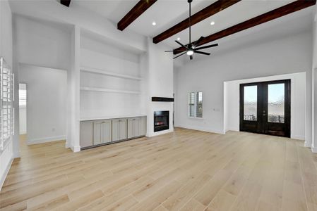 Living room showcasing built in shelving, a wood burning fire place, and a custom wood mantle.