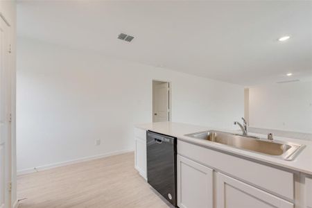 Kitchen with white cabinetry, sink, light hardwood / wood-style floors, and dishwasher