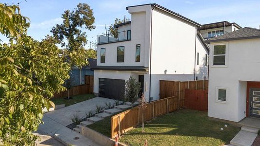 View of property exterior with a yard, a balcony, and a garage