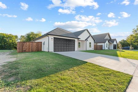 View of front of home featuring a front yard and a garage