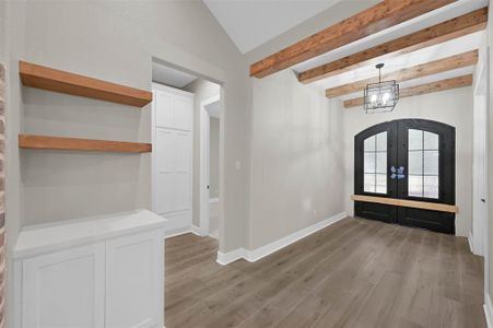 Front entry featuring cedar beams and to the right of the entry, a hallway that has tons of storage, that connects to the second and third bedrooms.