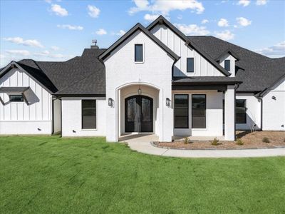 Rear view of property featuring a yard and french doors